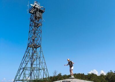 Nainen seisoo rannikkotykin päällä.