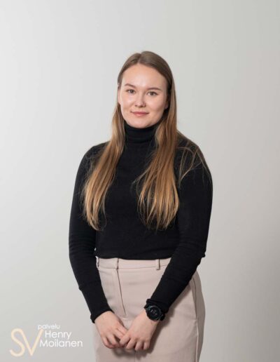 Nainen poseeraa kameralle ja hymyilee.