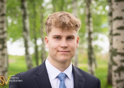 Nuori mies katsoo kameraan.