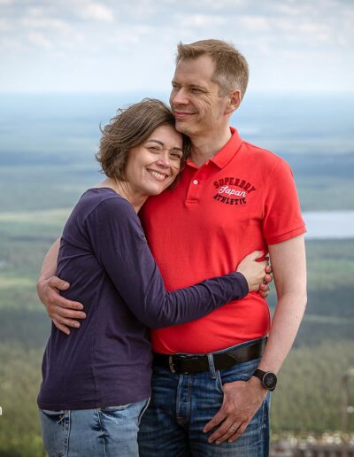 Nainen halaa miestä korkealla tunturissa.