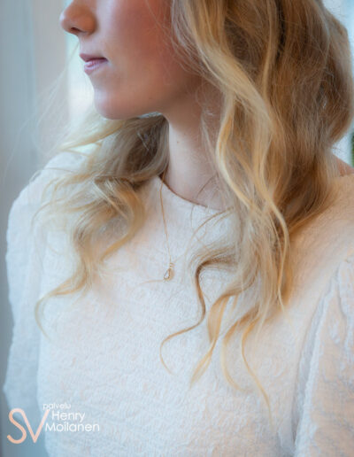 Naisella on riipus kaulassa.