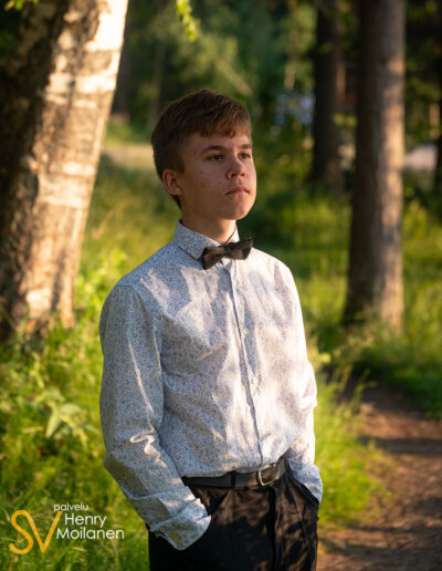 Poika seisoskelee polulla kädet taskuissa.