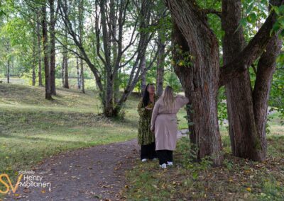 Kaksi naista juttelee puistossa.