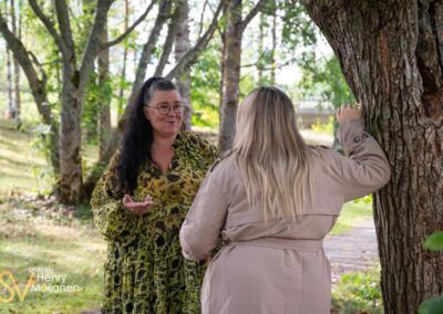 Kaksi naista juttelee puistossa.