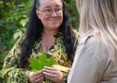 Terapeutti istuu naisen kanssa lehti kädessä.