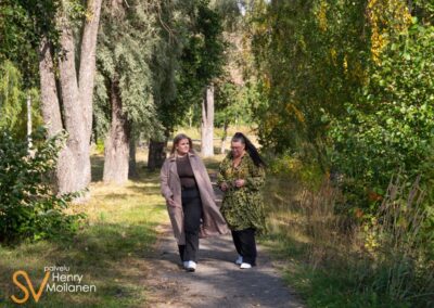 Kaksi naista kävelee puistossa.