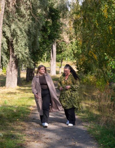 Kaksi naista kävelee puistossa.