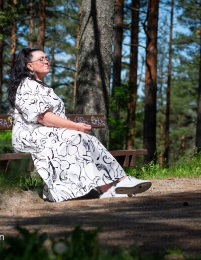 Nainen istuu penkillä silmät kiinni.