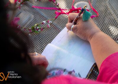 Nainen kirjoittaa kirjaan tekstiä.