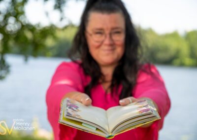 Nainen ojentaa kirjaa.