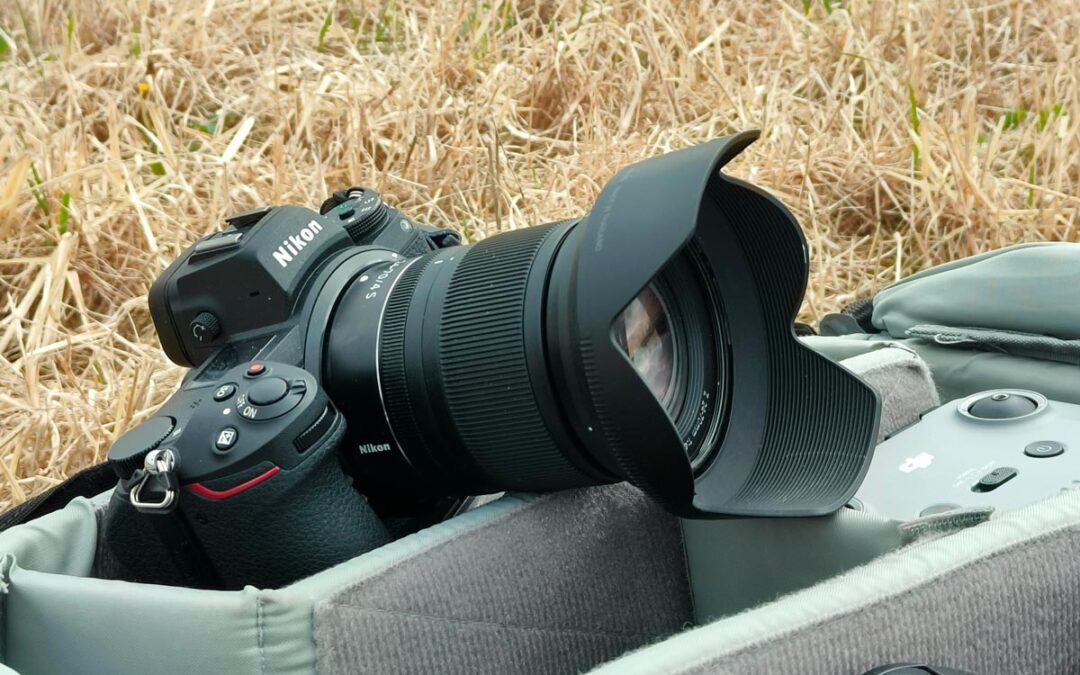 Nikon-järjestelmäkamera laukun päällä pellolla.